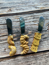 Load image into Gallery viewer, Set of THREE - bakery themed cheese knives (used, good condition)
